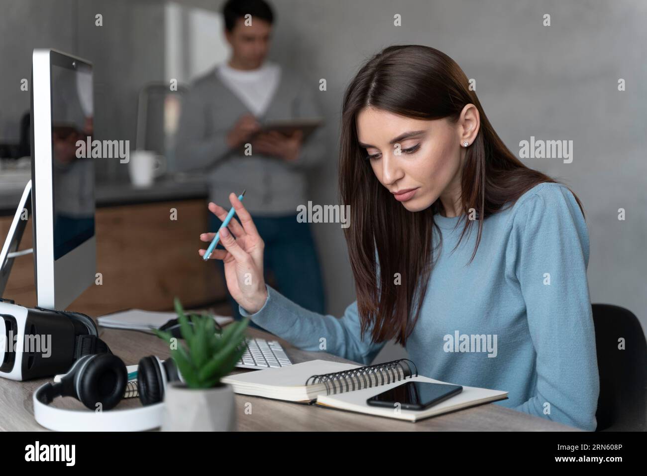 Donna che lavora nel settore multimediale con uno smartphone personal computer Foto Stock
