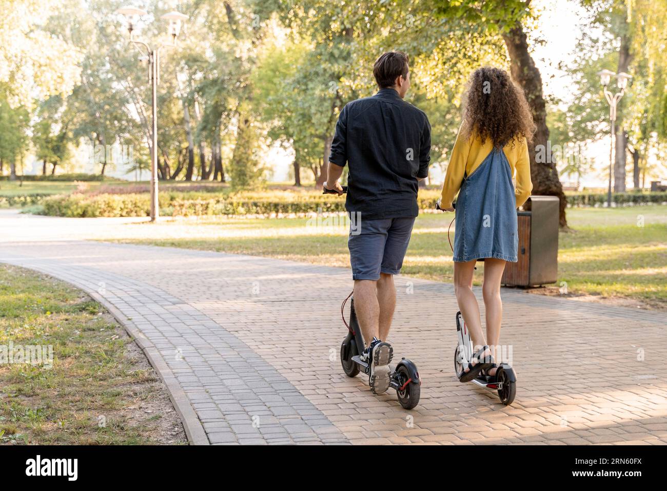 Graziosa giovane coppia che guida uno scooter all'aperto Foto Stock