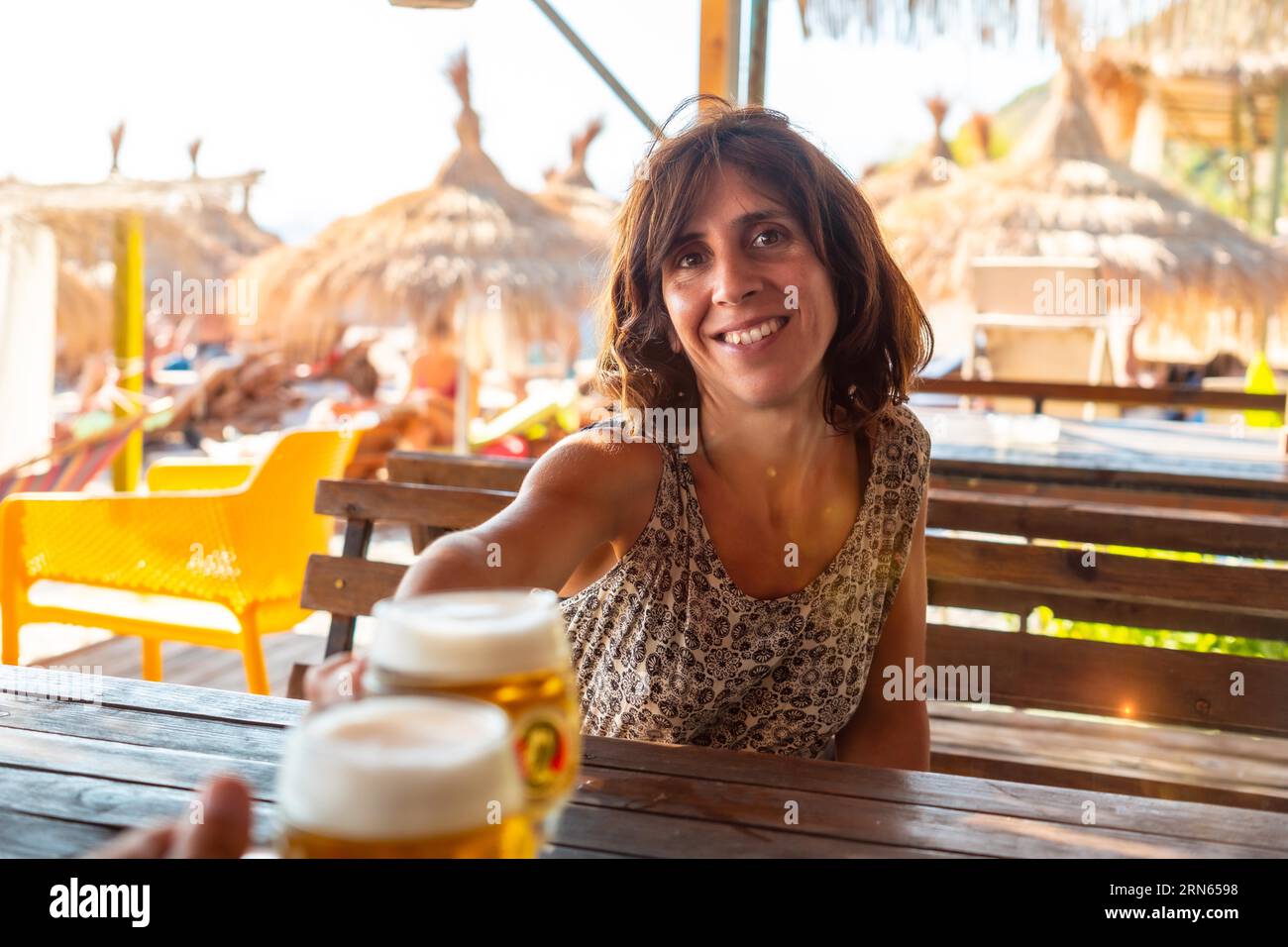 Brindisi di una coppia sulla spiaggia in estate bevendo qualche birra in una celebrazione dell'amicizia Foto Stock