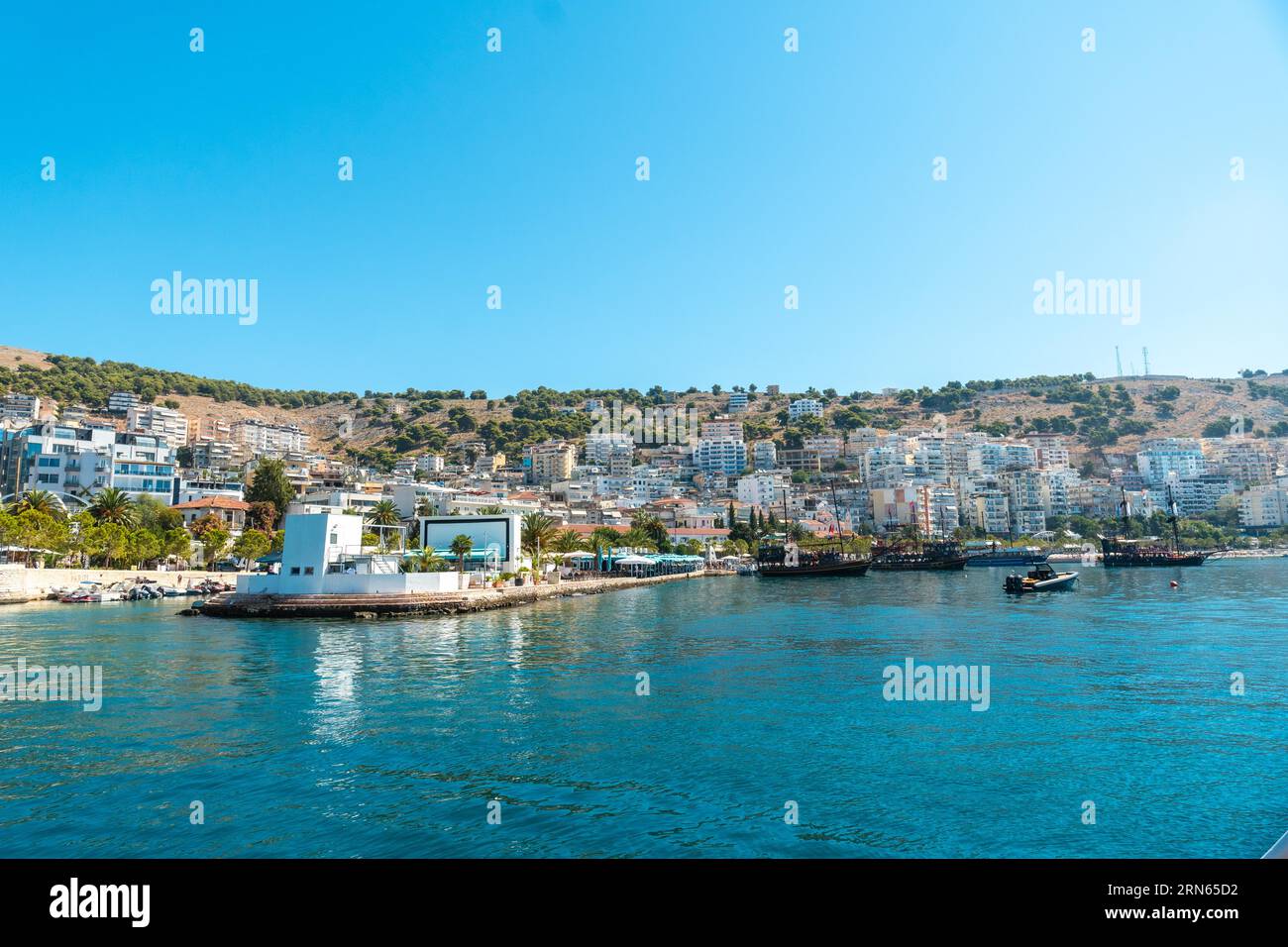 Spiagge e città di Sarande o Saranda sulla riviera albanese viste da una barca, l'Albania Foto Stock