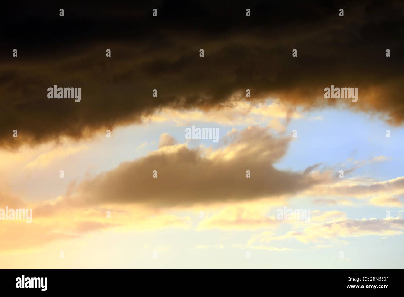 Cielo nuvoloso al tramonto. Il cielo è visibile attraverso uno spazio tra le nuvole. L'immagine trasmette l'atmosfera di una tempesta imminente o di un cattivo tempo Foto Stock