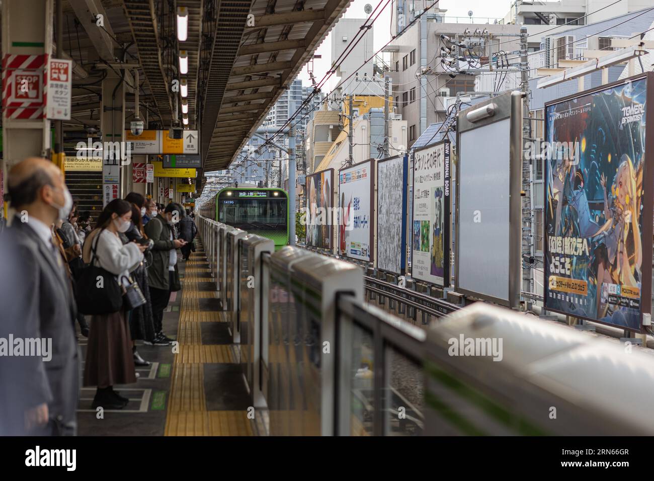 Treno della linea Yamanote in arrivo, persone in attesa sul binario, stazione di Takadanobaba, Shinjuku City, Tokyo Foto Stock