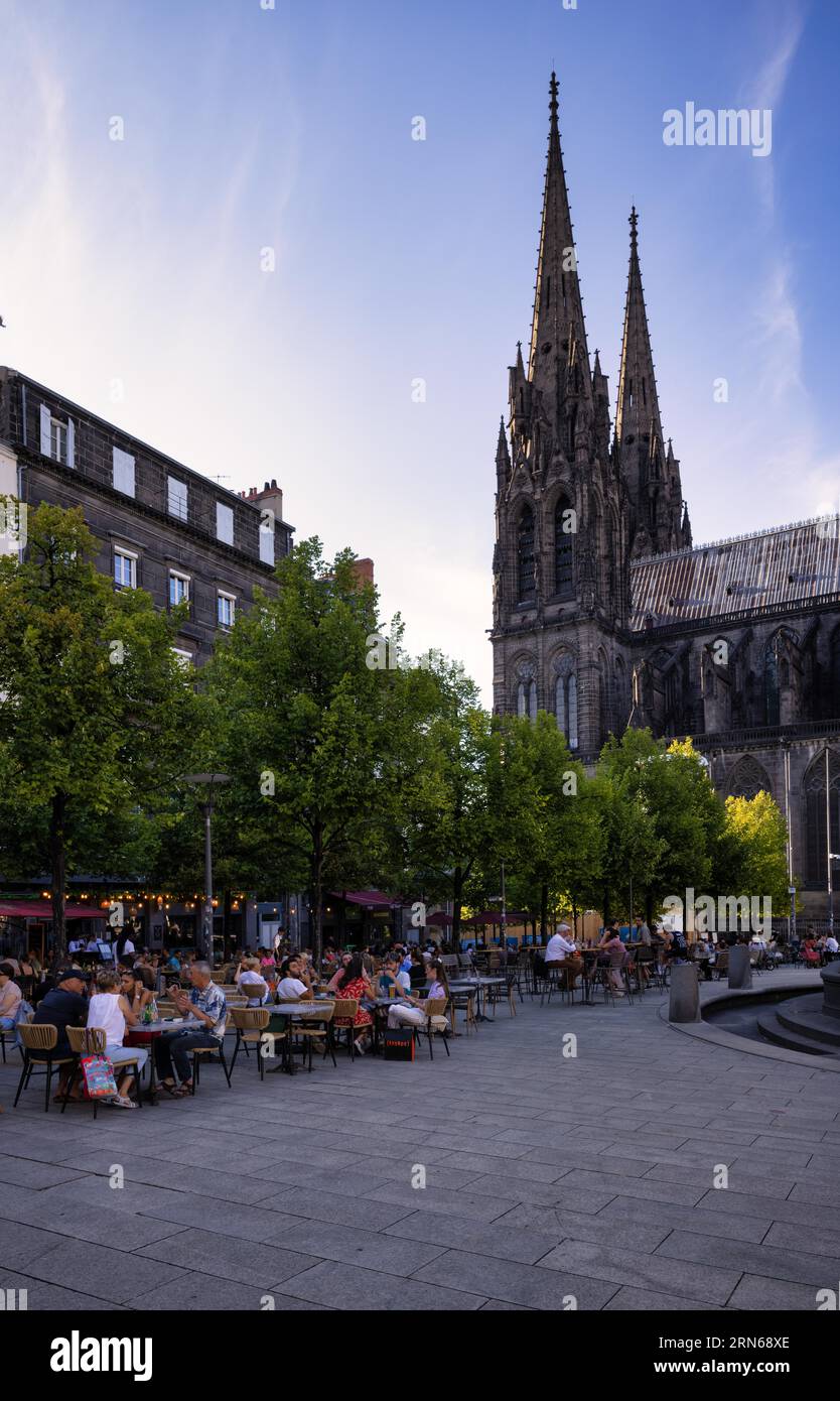 Gente che si gode l'estate in caffetterie e ristoranti di strada, Place de la Victoire, dietro la cattedrale Notre-Dame-de-l'Assomption, Clermont-Ferrand Foto Stock
