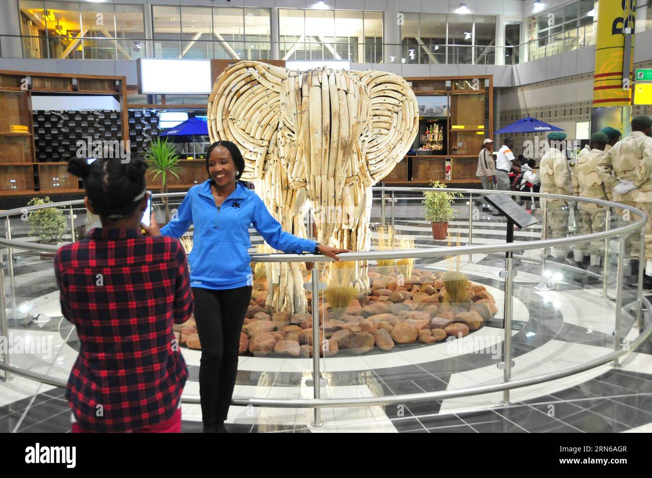 (150717) -- GABORONE, - Una donna posa per foto davanti a una scultura d'avorio all'aeroporto internazionale Sir Seretse Khama, a Gaborone, Botswana, il 16 luglio 2015. Giovedì il presidente del Botswana Seretse Khama Ian Khama ha svelato la scultura in avorio recuperata da elefanti morti in natura per dimostrare la posizione del Botswana nella protezione delle risorse naturali. BOTSWANA-GABORONE-IVORY SCULPTURE-UNVEILING LyuxTianran PUBLICATIONxNOTxINxCHN 150717 Gaborone una donna posa per le foto di fronte alla scultura avorio PRESSO L'aeroporto internazionale Sir SERETSE Khama di Gaborone in Botswana IL 1° luglio Foto Stock