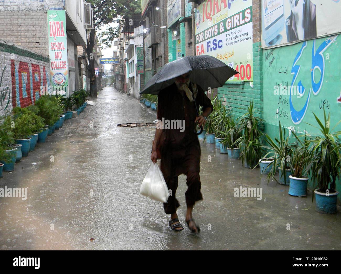 (150726) -- PESHAWAR, 26 luglio 2015 -- Un uomo usa un ombrello per ripararsi durante le pesanti piogge monsoniche a Peshawar, Pakistan nordoccidentale, 26 luglio 2015. Almeno 43 persone sono rimaste uccise, centinaia di altri feriti e decine di migliaia di sfollati in inondazioni e incidenti legati alle piogge nel Punjab, Khyber Pakhtunkhwa e nel Balochistan, hanno detto sabato i media e i funzionari locali. ) (Dzl) PAKISTAN-PESHAWAR-MONSONE PIOGGIA AhmadxSidique PUBLICATIONxNOTxINxCHN 150726 Peshawar luglio 26 2015 a Man Uses to Umbrella per ripararsi durante Heavy Monsoon Rain a Peshawar Northwest Pakistan luglio 26 20 Foto Stock