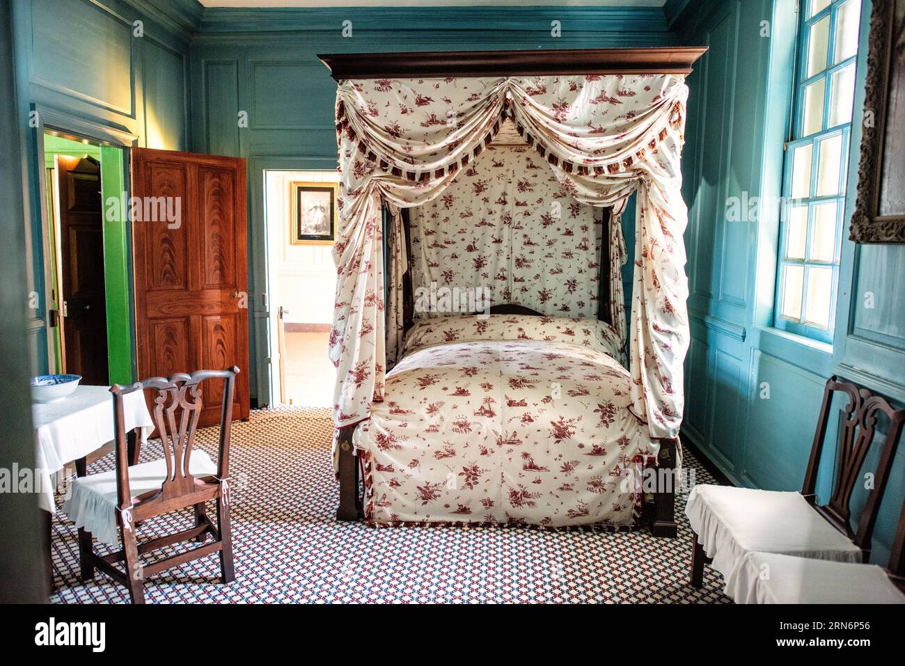 Mount Vernon Bedroom Alexandria Virginia // MOUNT VERNON, Alexandria, Virginia — Una camera da letto decorata in stile d'epoca a Mount Vernon, la storica tenuta di George Washington, primo presidente degli Stati Uniti. La sala, meticolosamente conservata, rappresenta i tipici quartieri domestici della fine del XVIII secolo, con arredi e decorazioni autentiche del periodo federale. Mount Vernon, situato lungo il fiume Potomac, servì come casa di Washington dal 1754 fino alla sua morte nel 1799. La villa di 21 camere e la tenuta circostante di 500 acri sono state mantenute dalla Mount Vernon Ladies' Association si Foto Stock