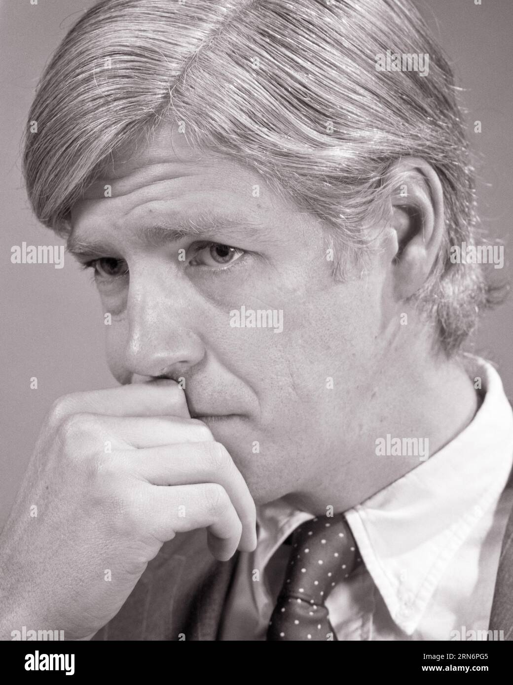 RITRATTO DEGLI ANNI '1970 DELL'UOMO MANO ALLA BOCCA E CHIN CON PREOCCUPATA ESPRESSIONE FACCIALE - P8216 HAR001 HARS UMORE GLOW PRIMO PIANO METÀ ADULTO METÀ ADULTO MISERA ETNIA CAUCASICA BIANCA E NERA HAR001 VECCHIO STILE Foto Stock