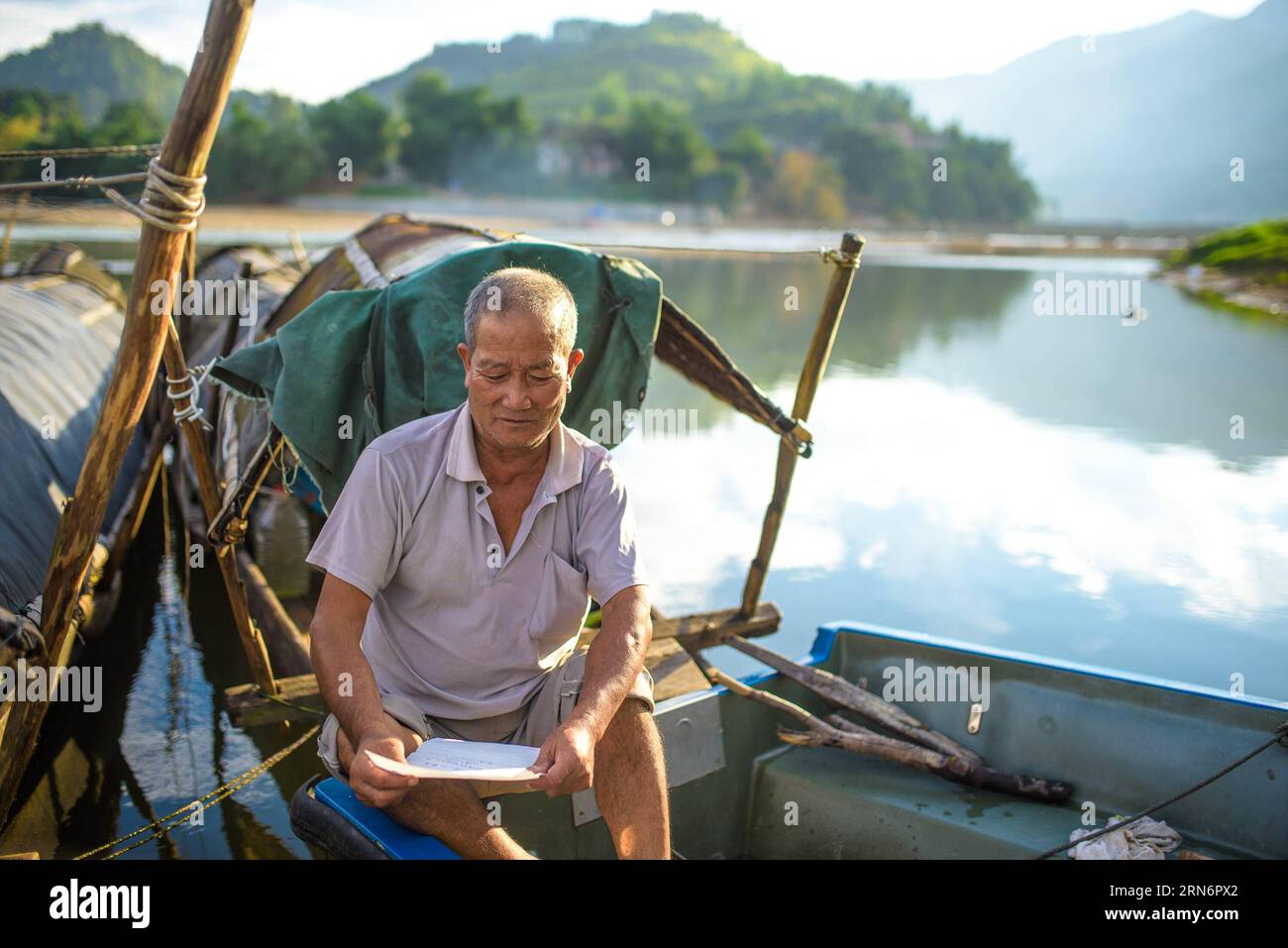 (150805) -- RONGJIANG, - Liang Yunquan legge una lettera di un abitante del villaggio il cui bambino una volta era stato salvato da lui dall'annegamento, nella contea di Rongjiang, nella provincia di Guizhou, nel sud-ovest della Cina, 4 agosto 2015. Liang ha salvato 22 persone dall'annegamento nel fiume Douliujiang durante i suoi 40 anni di traghetti. (wf) CHINA-GUIZHOU-BARCAIOLO (CN) LiuxXu PUBLICATIONxNOTxINxCHN 150805 Rongjiang Liang legge una lettera di un villaggio il cui bambino una volta ciò che GLI HA SALVATO dall'annegamento nella contea di Rongjiang nella provincia di Guizhou della Cina sud-occidentale 4 agosto 2015 Liang ha SALVATO 22 celebrità dall'annegamento nel fiume durante il suo 40 Yea Foto Stock