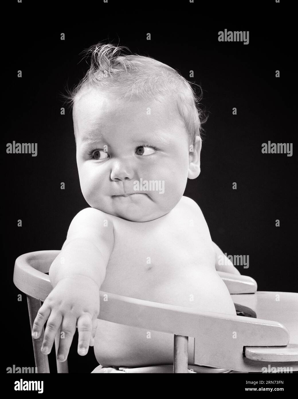 1950S DIFFIDENTE IL BAMBINO CHE SIEDE IN SEGGIOLONE GUARDANDO DIETRO DIETRO ALLE SPALLE - B5447 HAR001 HARS HEALTHINESS HOME LIFE COPY SPAZIO ESPRESSIONI DI TRASPORTO A MEZZA LUNGHEZZA TURBATI B&W PREOCCUPATI OBIETTIVI DI TRISTEZZA TENTAZIONE AFFAMATO FELICITÀ UMORE CRESCITA CONCETTUALE GLUM SEGGIOLONE GIOVANI INFELICI DIFFIDENTE BAMBINA NERA E BIANCA ETNIA CAUCASICA HAR001 VECCHIO STILE INCERTO Foto Stock