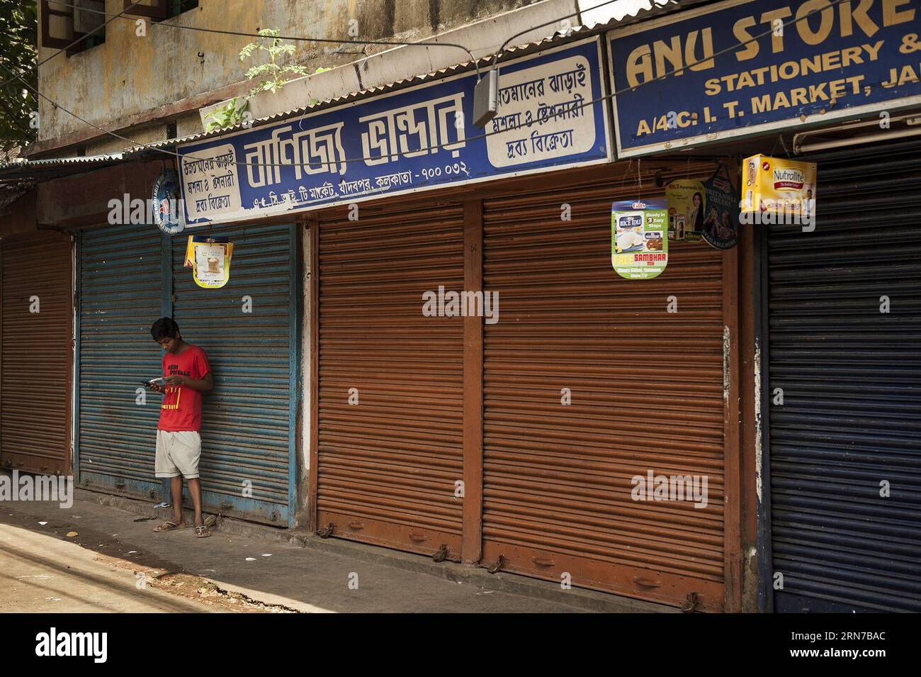 (150902) -- CALCUTTA, 2 settembre 2015 -- un ragazzo indiano si trova accanto a negozi chiusi durante uno sciopero di un giorno a Calcutta, capitale dello stato indiano orientale del Bengala occidentale, il 2 settembre 2015. La vita normale in India è stata gravemente colpita mercoledì, in quanto è stato organizzato uno sciopero nazionale da parte dei sindacati per protestare contro la riforma del diritto del lavoro e la privatizzazione dei settori pubblici da parte del governo del primo ministro Narendra modi . INDIA-KOLKATA-STRIKE TumpaxMondal PUBLICATIONxNOTxINxCHN 150902 Kolkata 2 settembre 2015 a Indian Boy si trova accanto a negozi chiusi durante un Day Long Strike a Calcutta, capitale dello stato dell'India orientale OCCIDENTALE Foto Stock