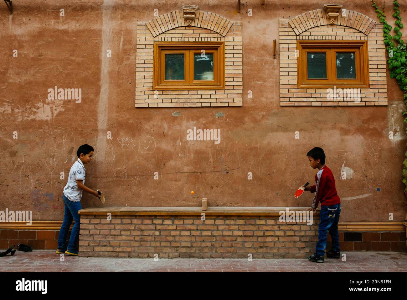 (150930) -- KASHGAR, 30 settembre 2015 -- i bambini giocano a ping pong su un tavolo trasformato da una lunga panchina nella città vecchia di Kashgar, regione autonoma di Xinjiang Uygur, nella Cina nord-occidentale, 20 settembre 2015. Kashgar, la città più occidentale della Cina, è stata per secoli il centro della civiltà uigura, un luogo dove le persone si sono riunite per commerciare e diffondere l'apprendimento islamico, sulle rotte carovane dall'Europa e dalla Persia alla Cina. (lfj) CHINA-XINJIANG-KASHGAR-OLD TOWN (CN) ZhangxCheng PUBLICATIONxNOTxINxCHN Kashgar settembre 30 2015 i bambini giocano a ping pong a un tavolo trasformato da una lunga panchina nel Foto Stock