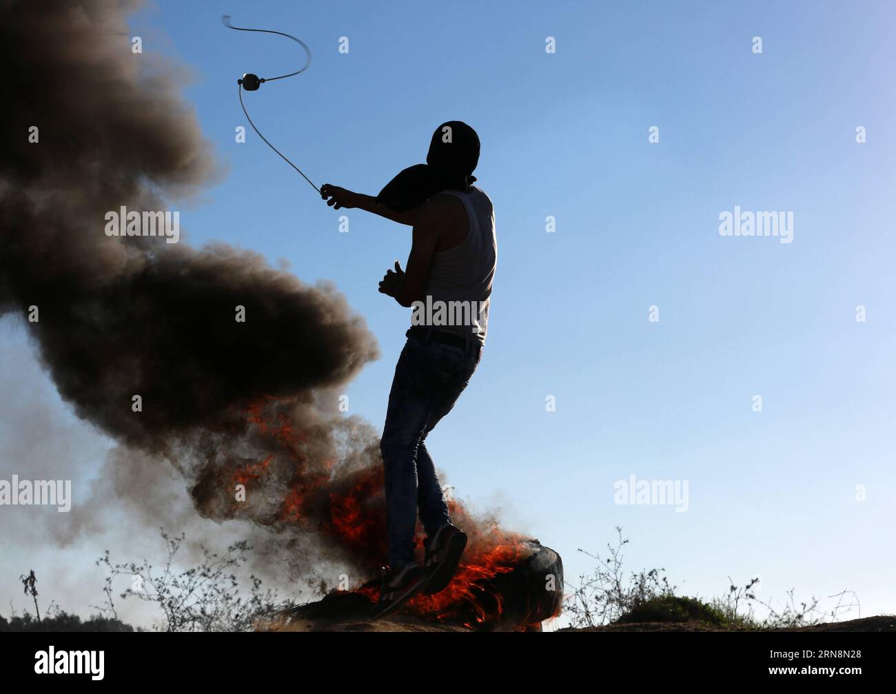 (151030) -- GAZA, 30 ottobre 2015 -- Un manifestante palestinese usa una fionda per lanciare pietre contro le truppe israeliane durante gli scontri vicino al confine tra Israele e la Striscia centrale di Gaza, 30 ottobre 2015. Tre palestinesi sono stati uccisi e più di 75 altri feriti in un giorno di forti tensioni e violenti scontri con le forze di sicurezza israeliane nei territori palestinesi, hanno detto i funzionari del ministero della salute venerdì. ) MIDEAST-GAZA-CLASH YasserxQudih PUBLICATIONxNOTxINxCHN Gaza OCT 30 2015 un manifestante PALESTINESE usa una fionda per lanciare pietre verso le truppe israeliane durante gli scontri vicino al Foto Stock