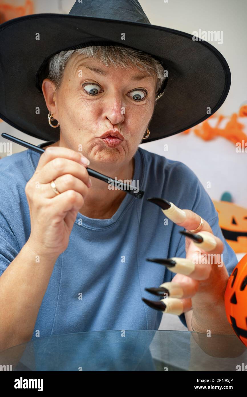 Senior dipinge unghie finte da costume da strega di Halloween Foto Stock