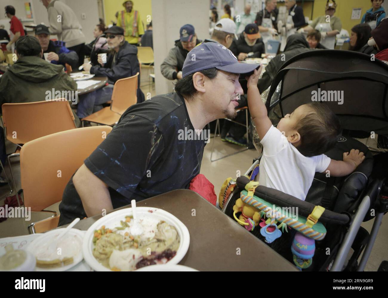 (151206) -- VANCOUVER, 5 dicembre 2015 -- Un residente gioca con suo figlio durante il pasto all'evento annuale gratuito Christmas Meal a Vancouver, Canada, 5 dicembre 2015. Circa 3.000 residenti che soffrono di povertà e senzatetto a Vancouver sono stati offerti pasti gratuiti dal 75° evento annuale gratuito di pasto di Natale della Union Gospel Mission per condividere la gioia prima del Natale. ) CANADA-VANCOUVER-FREE CHRISTMAS MEAL Liangxsen PUBLICATIONxNOTxINxCHN 151206 Vancouver DEC 5 2015 un residente GIOCA con il suo sole durante il pasto ALL'annuale Free Christmas Meal Event a Vancouver Canada DEC 5 2015 circa 3 000 residenti Foto Stock