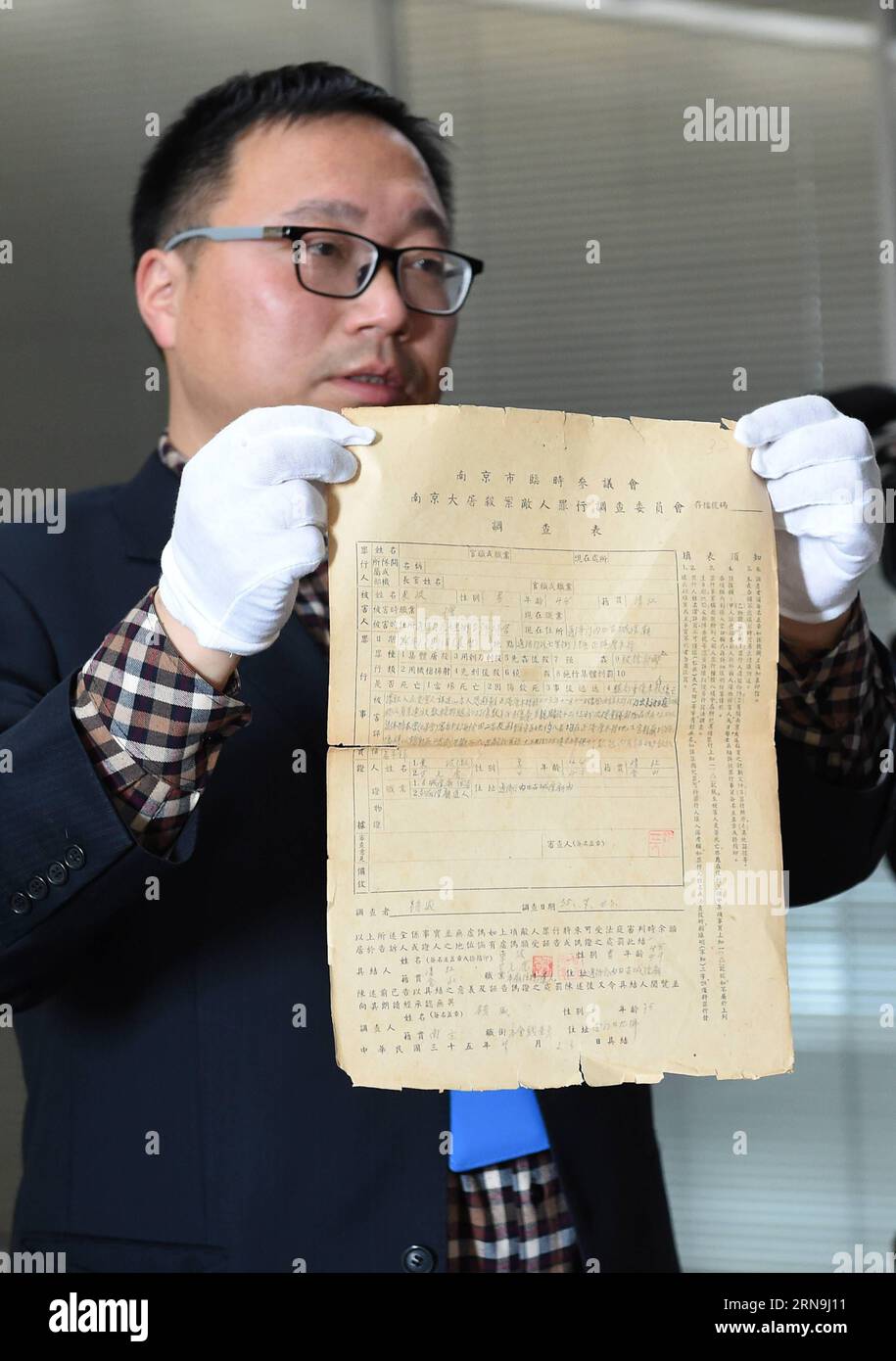 China präsentiert Forschungsergebnisse zum Massaker von Nanking (151208) -- NANCHINO, 8 dicembre 2015 -- Un membro dello staff dell'Archivio municipale di Nanchino mostra i file del massacro di Nanchino a Nanchino, capitale della provincia di Jiangsu della Cina orientale, l'8 dicembre 2015. La Cina ha pubblicato i fascicoli delle indagini sui crimini di guerra sul massacro di Nanchino prima della giornata commemorativa nazionale per l'atrocità. I 15 fascicoli sono solo una piccola selezione dei 2.784 che il Consiglio municipale provvisorio di Nanchino ha compilato tra luglio e novembre 1946 e che sono stati elencati nella memoria del Registro Mondiale da U Foto Stock