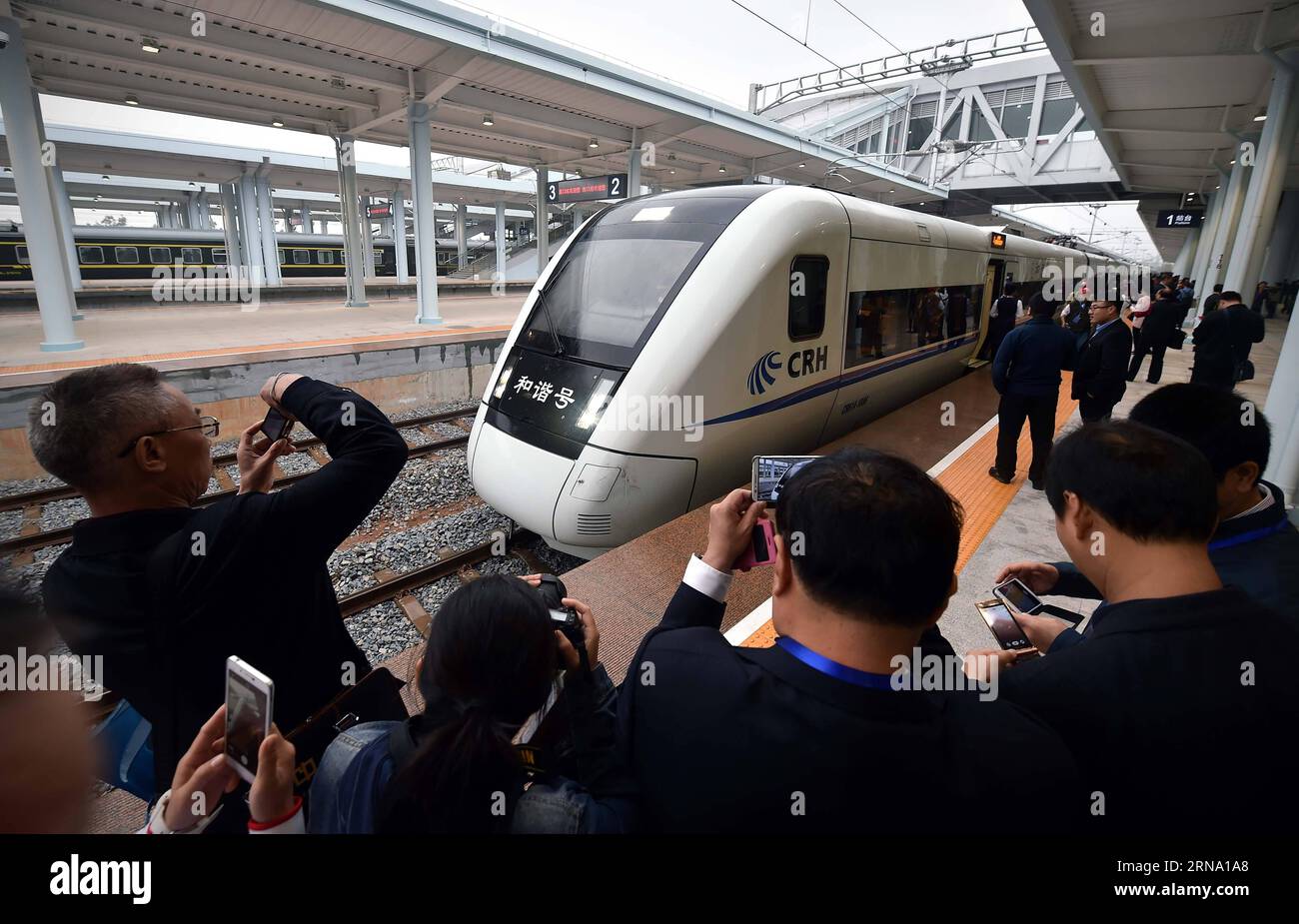 (151230) -- HAIKOU, 30 dicembre 2015 -- i passeggeri scattano foto di un treno che gestisce la nuova ferrovia ad alta velocità a Haikou, capitale della provincia di Hainan della Cina meridionale, 30 dicembre 2015. La Western Ring Railway di 345 km a Hainan fu messa in funzione mercoledì, completando la prima linea ferroviaria ad alta velocità al mondo che circonda un'isola. Il tratto occidentale, con una velocità progettata di 200 km all'ora, ha 16 fermate in sei città e contee, che collegano la capitale provinciale Haikou con Sanya, un luogo turistico tropicale. (Zwx) FERROVIA AD ALTA VELOCITÀ CINA-HAINAN (CN) GuoxCheng PUBLICATIONxNOTxINxCHN Haikou DEC 30 2015 Pa Foto Stock