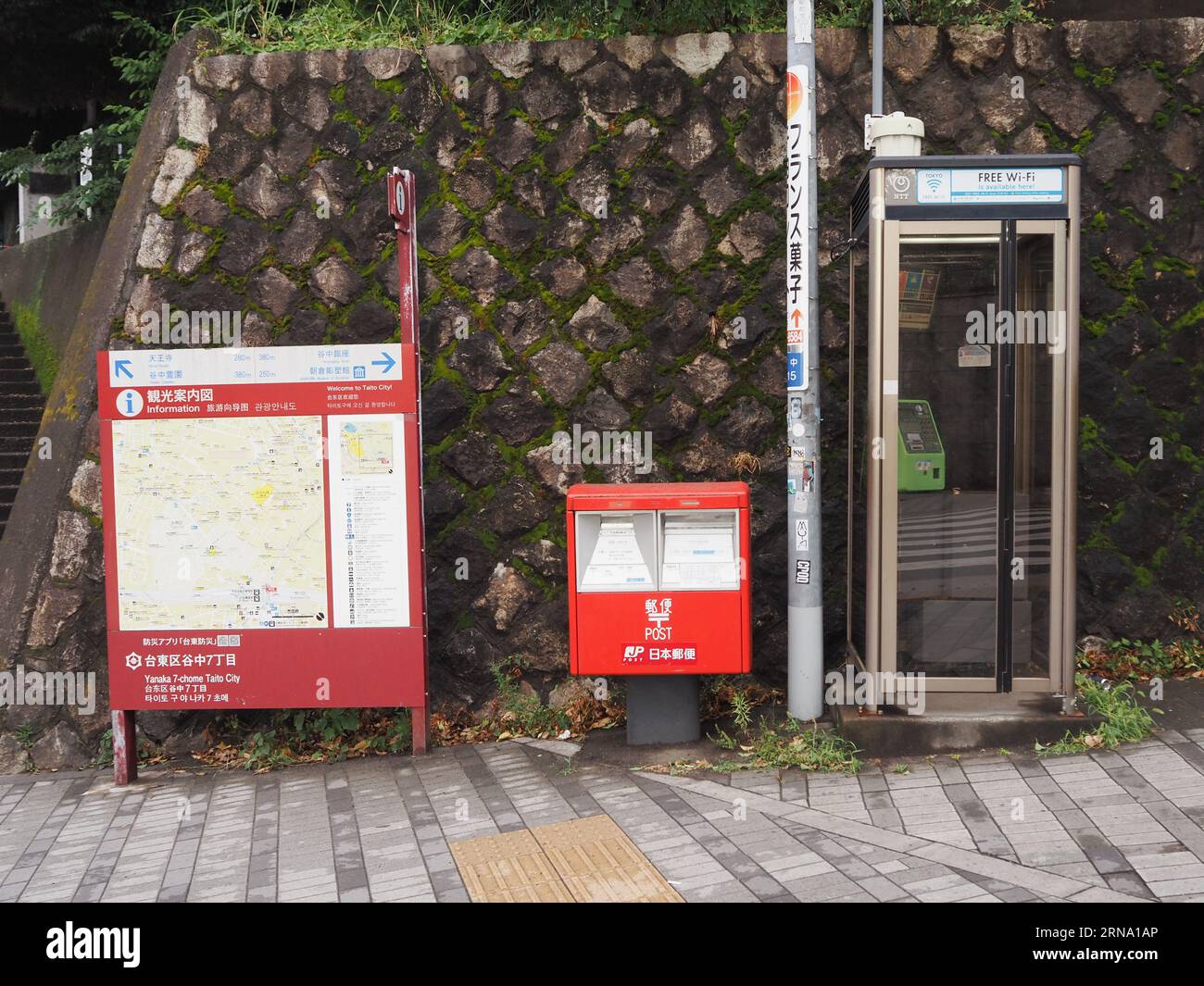 TOKYO, GIAPPONE - 1 agosto 2023: Una strada nel quartiere Taito di Tokyo con cabina telefonica. casella postale e mappa dell'area. Foto Stock