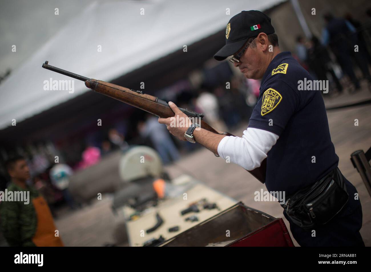 (160112) -- CITTÀ DEL MESSICO, 12 gennaio 2016 -- Un poliziotto controlla un'arma durante la sesta fase del programma per la vostra famiglia, disarmo volontario , presso la Cattedrale metropolitana, a città del Messico, capitale del Messico, il 12 gennaio 2016. Secondo la stampa locale il governo del Distretto Federale (GDF, per il suo acronimo in spagnolo), ha effettuato la sesta fase di scambio di armi attraverso il programma per la vostra famiglia, il disarmo volontario , in cui la gente può scambiare armi e pistole giocattolo per denaro, provviste e dispositivi elettronici. Le armi scambiate sono esaminate dai membri della polizia e.. Foto Stock