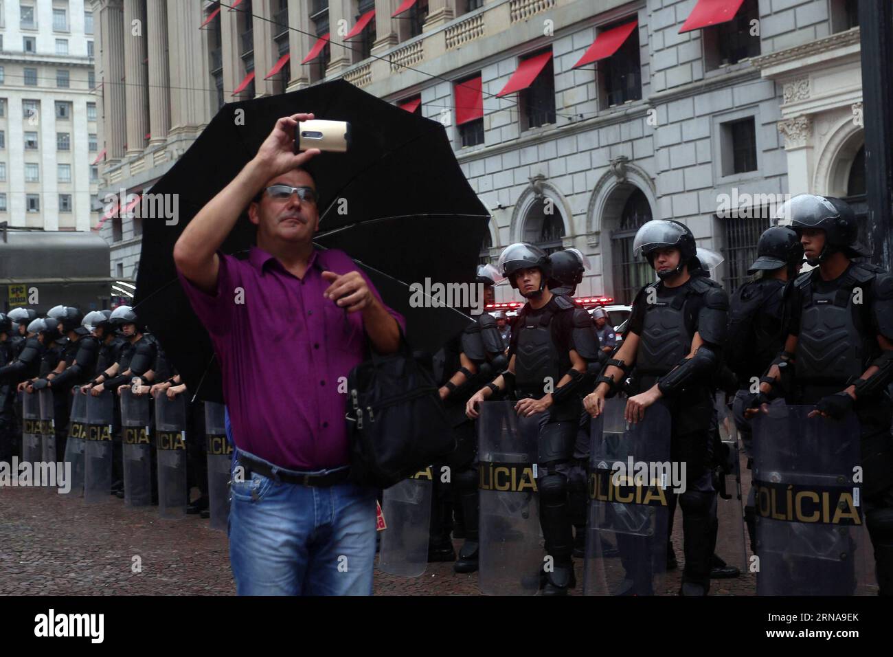 SAN PAOLO, -- Un uomo scatta una foto davanti ai poliziotti, durante una protesta contro l'aumento delle tariffe dei trasporti, a San Paolo, Brasile, il 14 gennaio 2016. Secondo la stampa locale, la protesta contro l'aumento delle tariffe dei trasporti pubblici a San Paolo, è stata organizzata dal Movimiento Passe Livre (movimento Free fare). Rahel Patrasso) (azp) BRASILE-SAN PAOLO-SOCIETÀ-PROTESTA e RahelxPatrasso PUBLICATIONxNOTxINxCHN Sao Paulo a Man Takes a Picture di fronte ai poliziotti durante una protesta contro l'escursione dei trasporti fare a San Paolo in Brasile IL 14 gennaio 2016 secondo la stampa locale la protesta contro il Publ Foto Stock