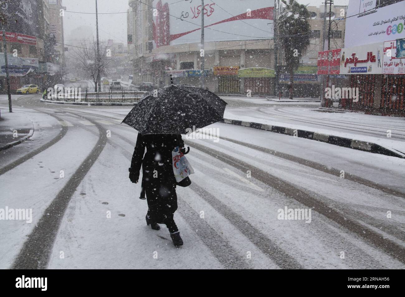 (160126) -- HEBRON, 26 gennaio 2016 -- Una donna palestinese cammina per strada durante una tempesta di neve nella città di Hebron in Cisgiordania, il 26 gennaio 2016. Le condizioni meteorologiche piovose in tutta la regione continuarono quando forti tempeste colpirono l'area con neve e piogge torrenziali. ) MIDEAST-HEBRON-SNOW MamounxWazwaz PUBLICATIONxNOTxINxCHN 160126 Hebron Jan 26 2016 una donna PALESTINESE cammina per strada durante una tempesta di neve nella città di Hebron IN CISGIORDANIA IL 26 2016 gennaio le condizioni meteorologiche in tutta la regione continuarono mentre forti tempeste colpirono l'area con neve e piogge torrenziali Mideast Hebron Snow Mamounx Foto Stock
