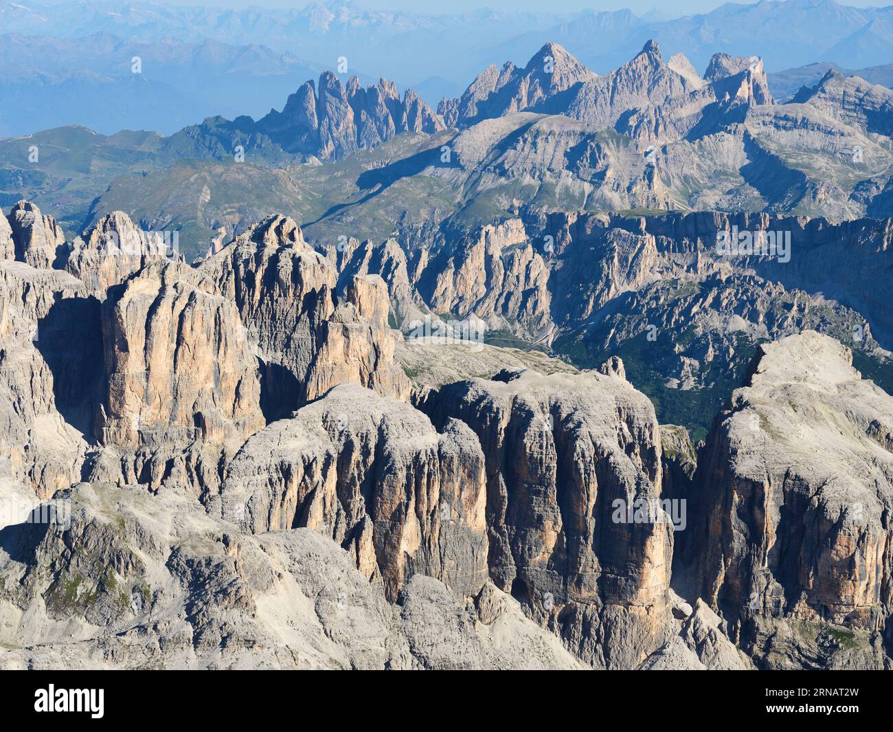 VISTA AEREA. Il paesaggio incredibilmente frastagliato del massiccio del Sella con il Parco naturale Puez-Geisler in lontananza. Dolomiti, Italia. Foto Stock