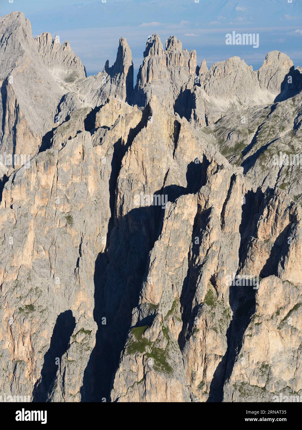 VISTA AEREA. Il frastagliato massiccio orientale del Catinaccio nelle Dolomiti con le Torri Vajolet (2821 m) in lontananza. Trentino-alto Adige, Italia. Foto Stock