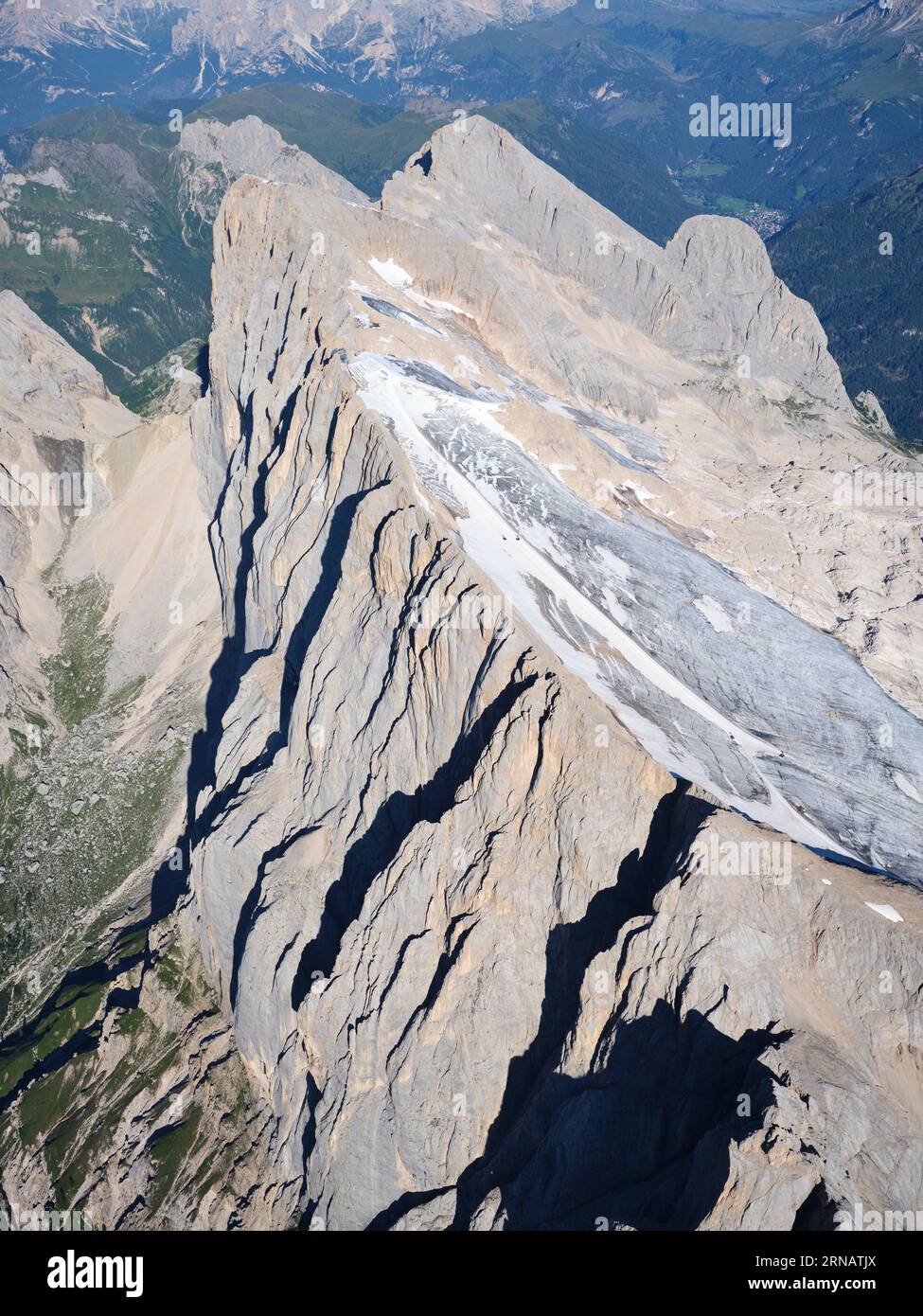 VISTA AEREA. Cima della Marmolada (3343 m) con la scogliera meridionale (in Veneto) e i ghiacciai settentrionali (in Trentino-alto Adige). Dolomiti, Italia. Foto Stock