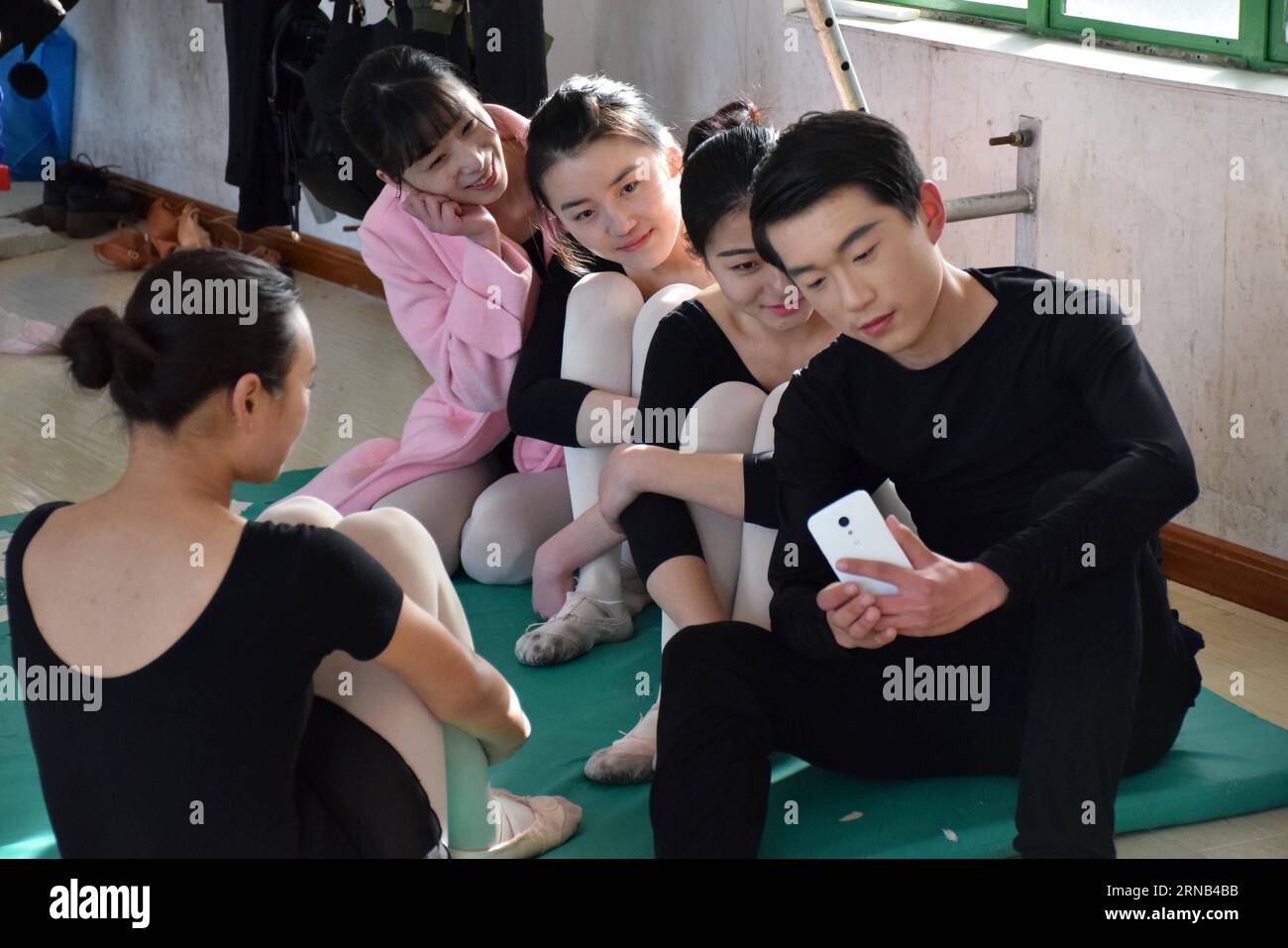 Gli studenti posano per un selfie durante una pausa alla scuola di danza del sole nella contea di Runan di Zhumadian, nella provincia di Henan, nella Cina centrale, 16 febbraio 2016. Quegli studenti che perseguono il loro sogno di essere ballerini erano impegnati a prepararsi per l'esame d'ingresso di un professionista d'arte. Esercitano tecniche essenziali e azioni di danza di routine più e più volte in un allenamento di 15 giorni prima dell'esame. )(mcg) CHINA-HENAN-ZHUMADIAN-ART PROFESSIONAL EXAM-TRAINING (CN) SunxKai PUBLICATIONxNOTxINxCHN gli studenti posano per Selfie durante una pausa ALLA Sunshine Dancing School di Runan County di Zhumadian Cent Foto Stock