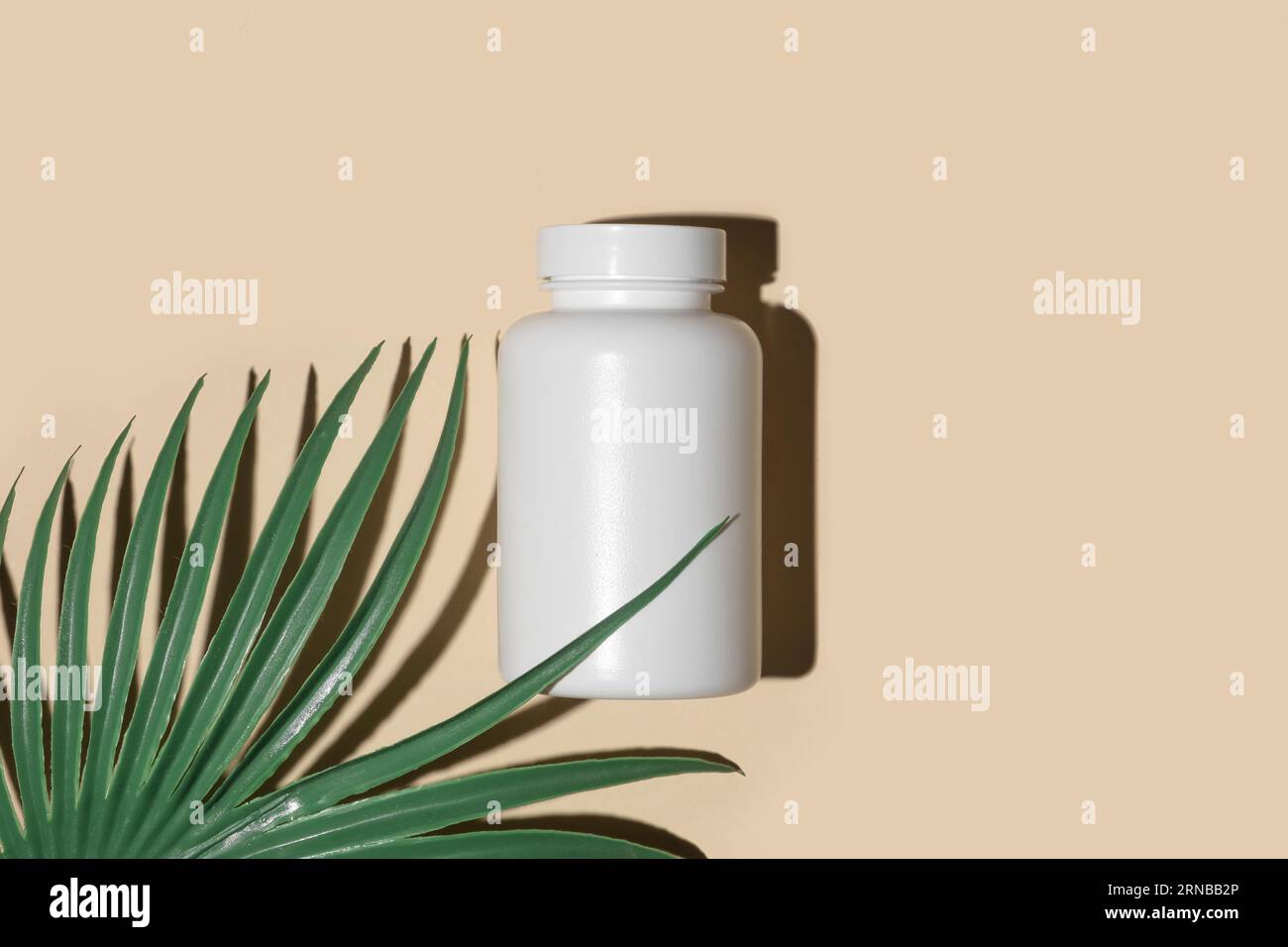Bottiglia supplemento bianco. Un modello di medicina. Modello vitaminico con etichetta vuota. Vasetto per pillole biologiche naturali. Sfondo a colori beige studio. Confezione trasparente. Foto Stock