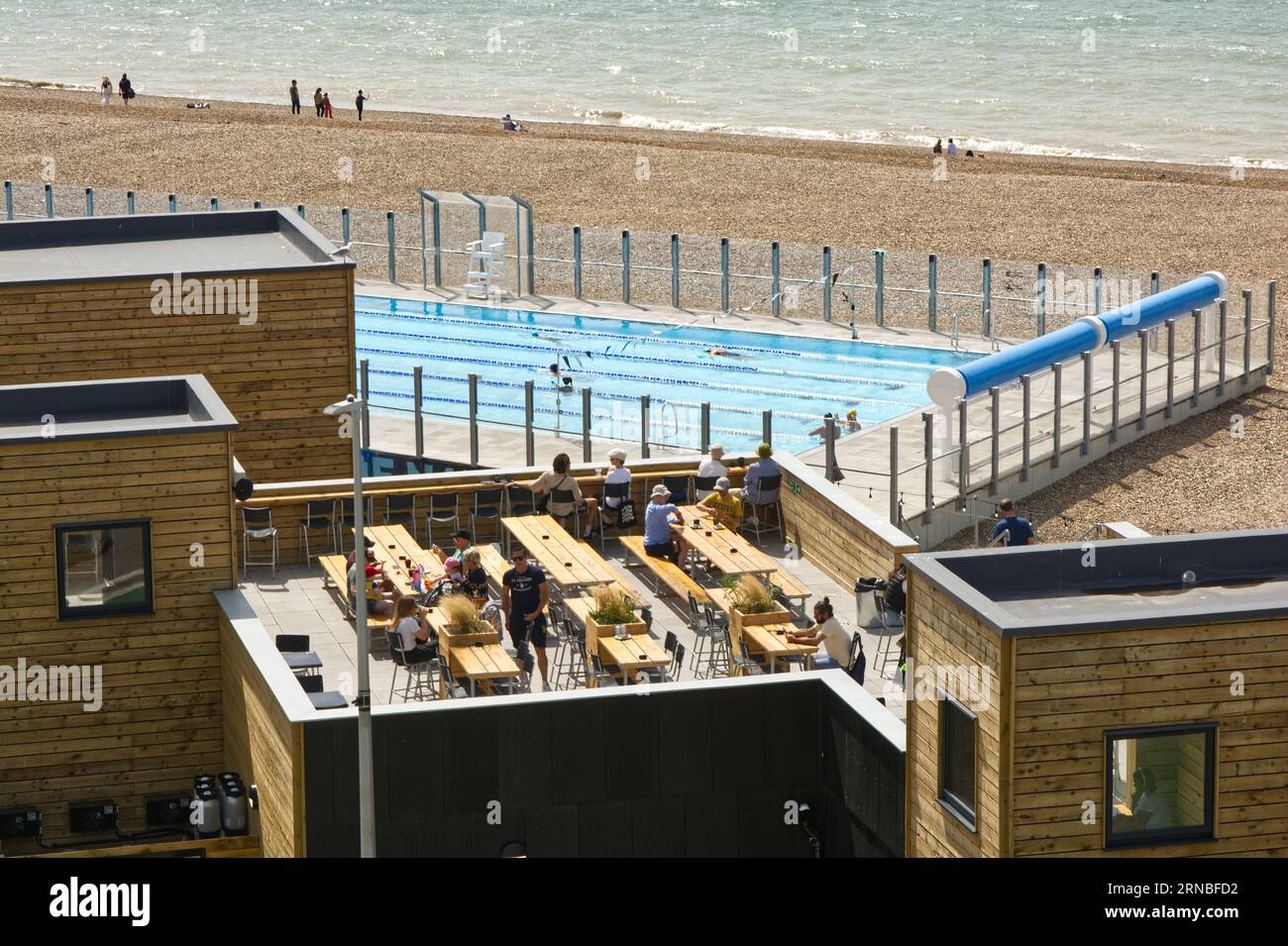 Nuovo complesso con piscina e ristorante sul lungomare di Brighton nell'East Sussex, Inghilterra. Con le persone che si divertono al mare. Foto Stock