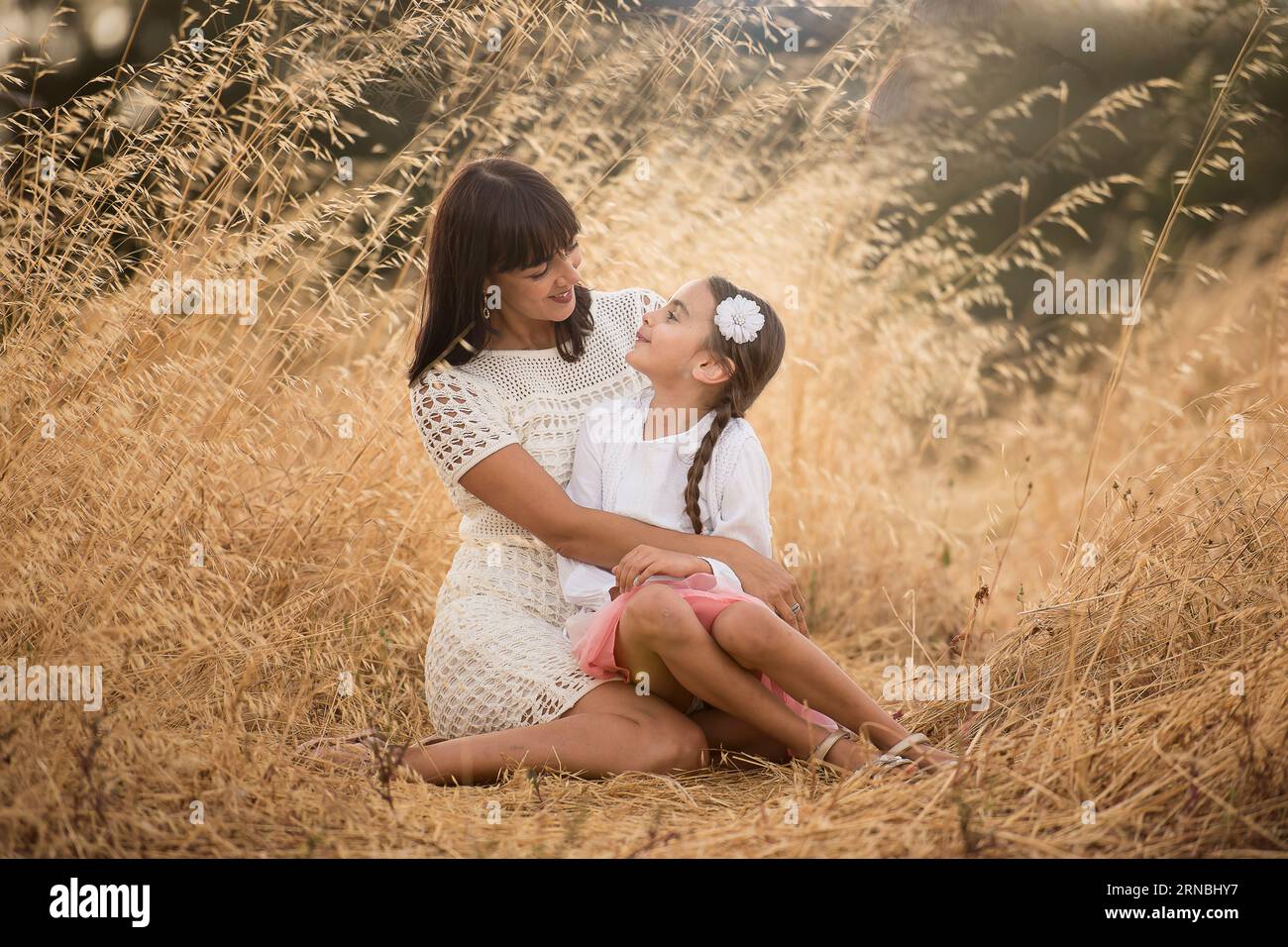 madre e figlia sedute a terra nel pomeriggio Foto Stock