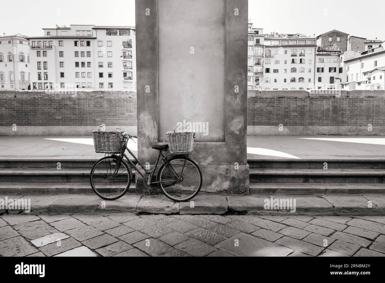 Bicicletta parcheggiata sull'argine vicino al fiume Arno, Mood Foto Stock