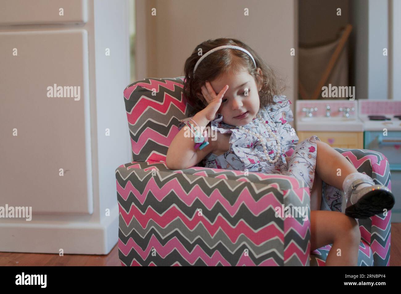 Una bambina nella sua stanza che si comporta da adulta Foto Stock