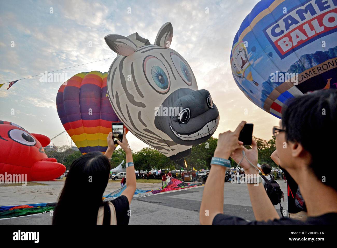 (160311) -- PUTRAJAYA (MALESIA), 11 marzo 2016 -- i turisti scattano foto di mongolfiere durante l'8a Putrajaya International Hot Air Balloon Fiesta a Putrajaya, Malesia, 11 marzo 2016. La festa di tre giorni in mongolfiera ha aperto qui il venerdì con la partecipazione di circa 20 mongolfiere. MALESIA-PUTRAJAYA-FESTIVAL-MONGOLFIERE ChongxVoonxChung PUBLICATIONxNOTxINxCHN Putrajaya Malesia 11 marzo 2016 i turisti scattano foto delle mongolfiere durante l'8a Putrajaya International Hot Air Balloon Fiesta a Putrajaya Malesia 11 marzo 2016 The Three Day Hot Air Balloon Fiesta op Foto Stock