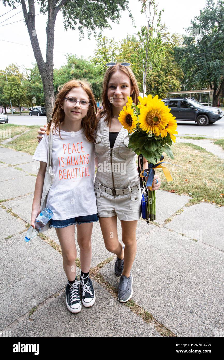 Due studentesse ucraine a Kiev hanno preparato fiori per il primo giorno di scuola con il motto della maglietta della ragazza più giovane la pace è sempre bella... Foto Stock