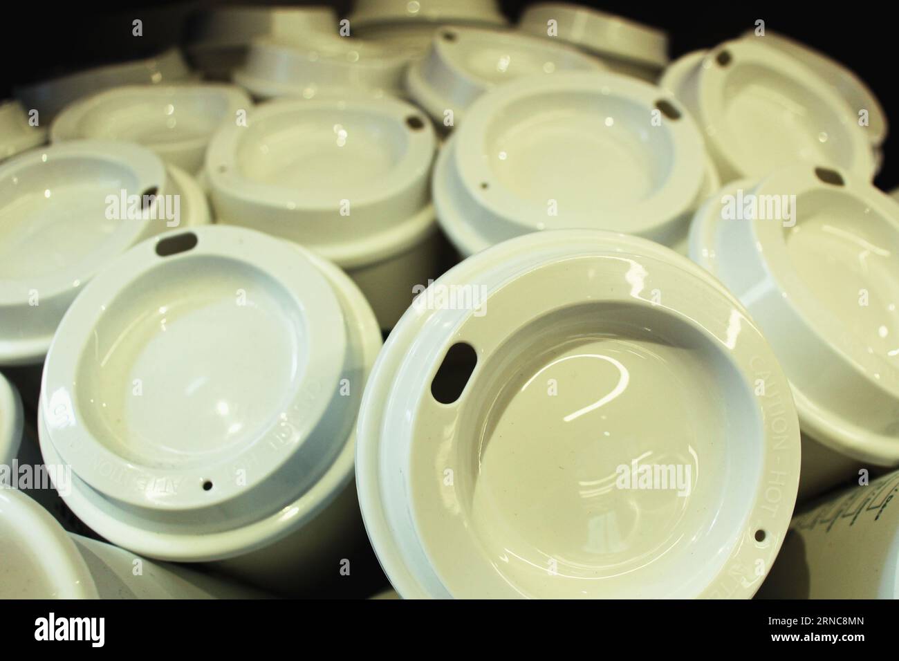 In un cestello, è possibile vedere da vicino le tazze da caffè da asporto in plastica bianca. Foto di alta qualità Foto Stock