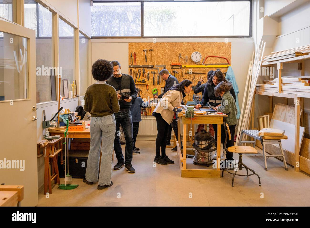 Clienti e lavoratori in un'officina di riparazione elettronica presso il centro di riciclaggio Foto Stock