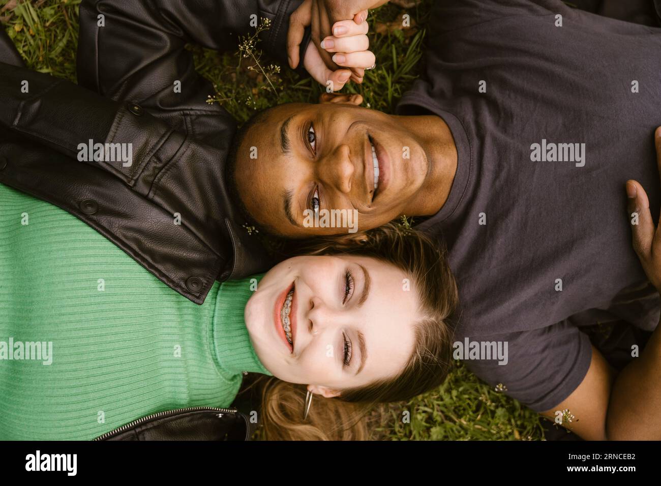 Direttamente sopra la vista di una giovane donna felice e di un uomo sdraiato sull'erba Foto Stock