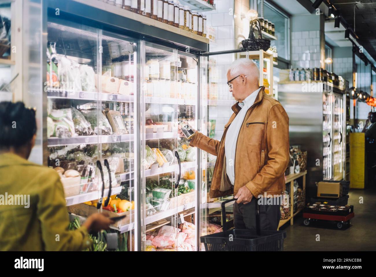 Senior man che analizza il vaso al supermercato Foto Stock