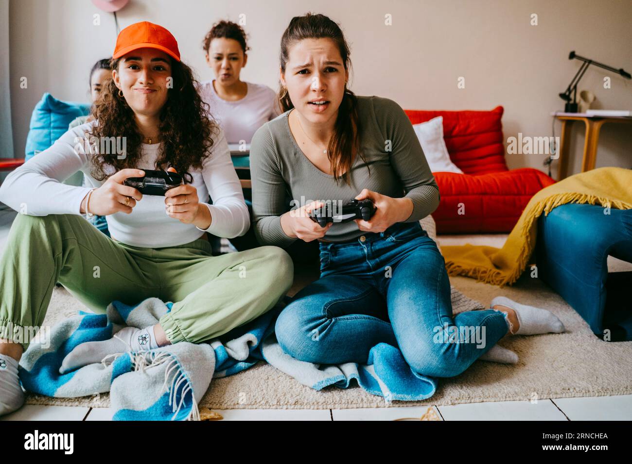 Giovani amiche che giocano ai videogame a casa Foto Stock