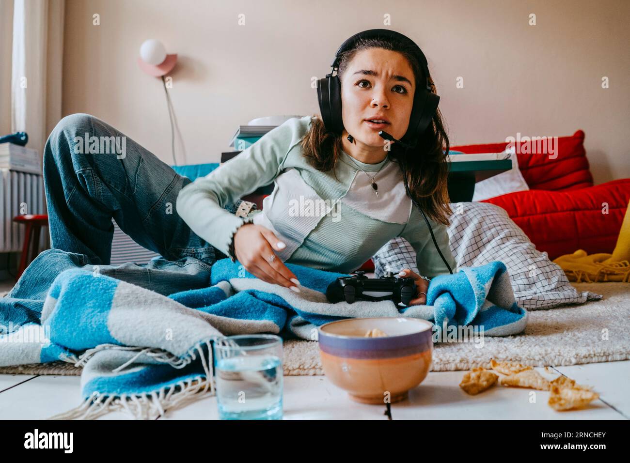 La donna la riproduzione del video gioco nel salotto di casa Foto Stock