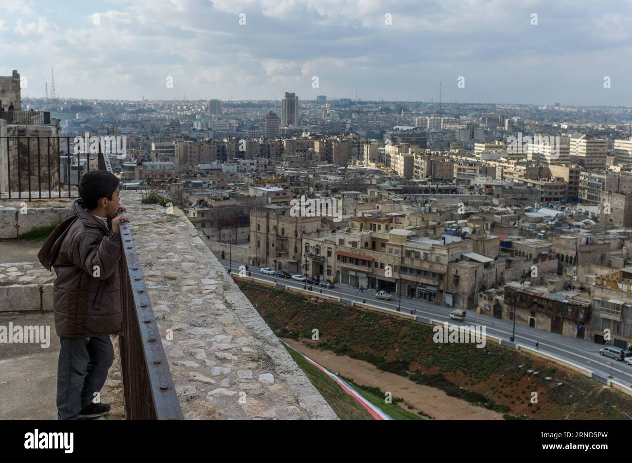 (160505) -- BEIJING, May 5, 2016 -- File photo taken on Jan. 19, 2012 shows a boy looking at the old city of Aleppo from the citadel of Aleppo, Syria. The citadel of Aleppo is a large medieval fortified palace in the center of the old city of Aleppo. )(zhf) SYRIA-ALEPPO-FILE LixMuzi PUBLICATIONxNOTxINxCHN   160505 Beijing May 5 2016 File Photo Taken ON Jan 19 2012 Shows a Boy Looking AT The Old City of Aleppo from The Citadel of Aleppo Syria The Citadel of Aleppo IS a Large Medieval fortified Palace in The Center of The Old City of Aleppo zhf Syria Aleppo File LiXMuzi PUBLICATIONxNOTxINxCHN Foto Stock