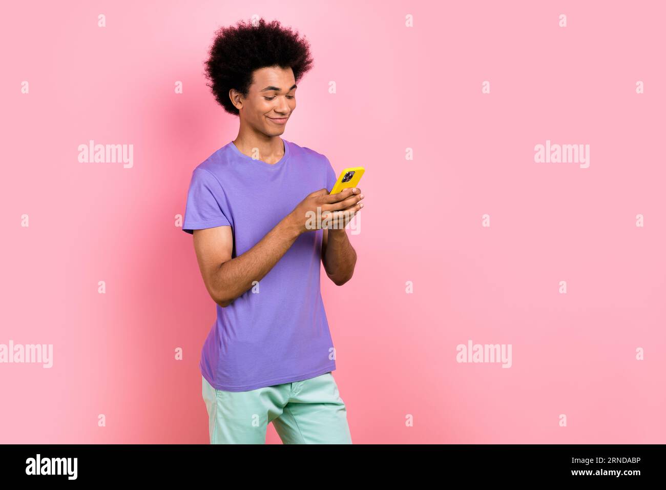 Foto di un uomo eccentrico e simpatico che indossa abiti viola alla moda leggi instagram facebook twitter post spazio vuoto isolato su sfondo rosa Foto stock Alamy