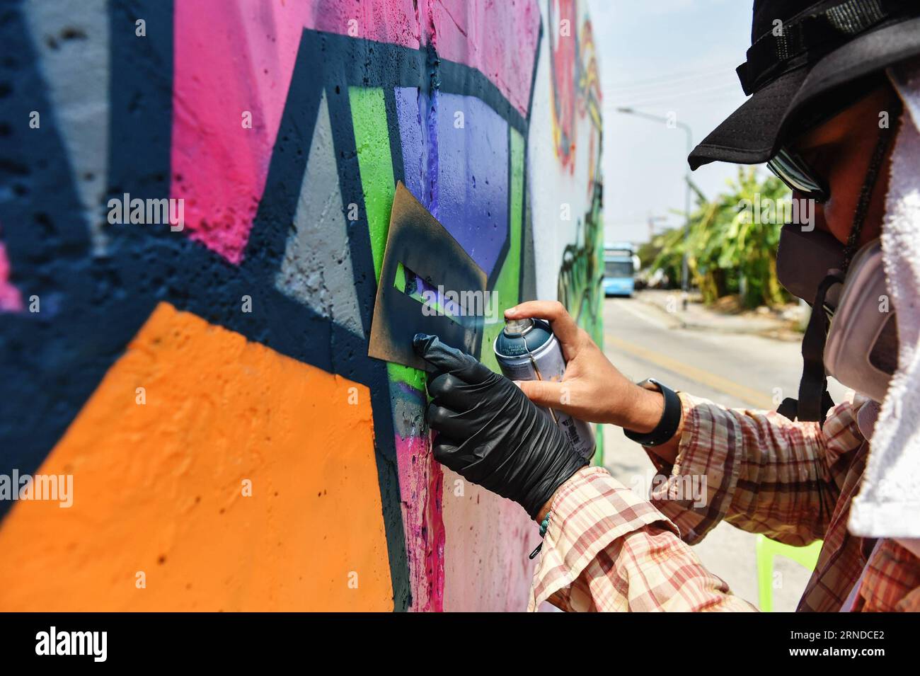 (160515) -- NAKHON SAWAN, 15 maggio 2016 -- Un artista di strada spruzza vernice sui suoi graffiti all'esterno di un impianto locale di trattamento delle acque reflue nella città di Nakhon Sawan, nella Thailandia centrale, il 15 maggio 2016. Oltre sessanta artisti di strada provenienti da tutta la Thailandia sono stati invitati dal governo municipale al Nakhon Sawan Street Art Project dal 13 al 15 maggio. Nel giro di tre giorni, gli artisti sono riusciti a trasformare le pareti esterne vuote di un impianto locale di trattamento delle acque reflue in una galleria di graffiti che si estende per circa 400 metri. ) THAILANDIA-NAKHON SAWAN-CULTURA POP-STREET ART-GRAFFITI Foto Stock