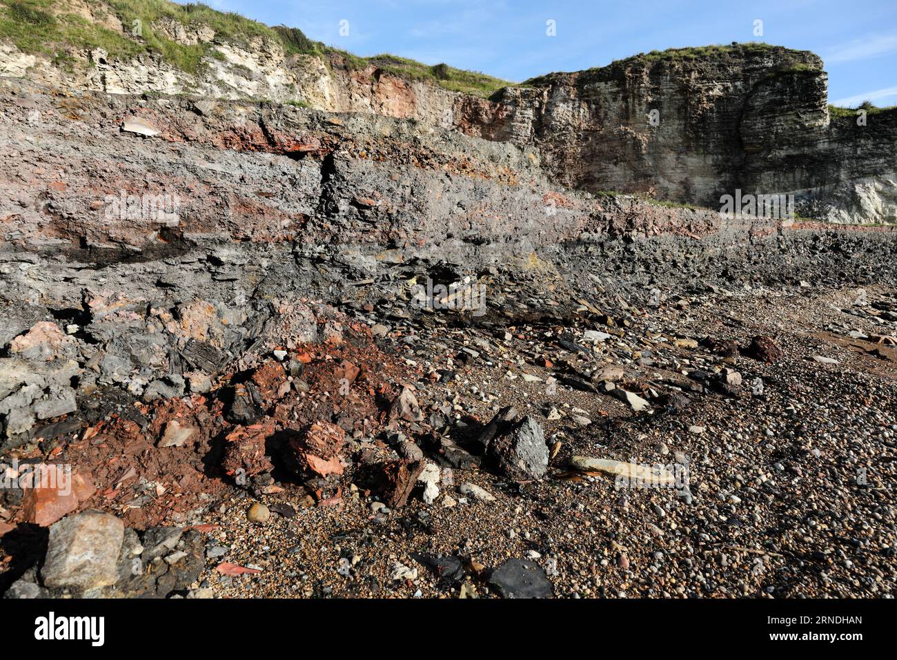 Strati di miniere di carbone e rifiuti di altoforni insieme ad altri detriti industriali che vengono lentamente erosi e lavati via dal mare sulla Blast Bea Foto Stock