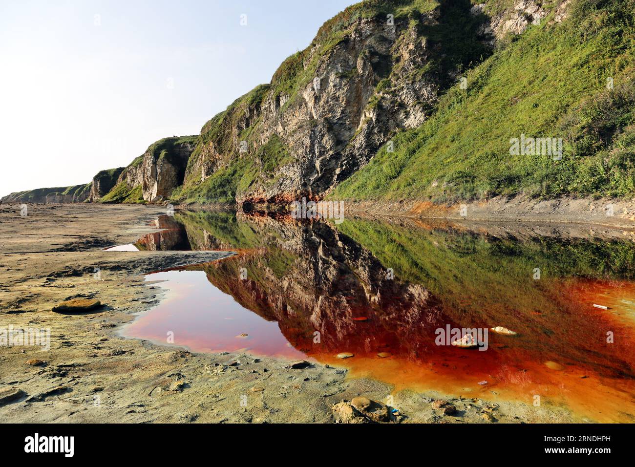 Piscine rosse di sangue con coste di zolfo gialle sulla Blast Beach, Durham Heritage Coast, Seaham, County Durham, UK Foto Stock