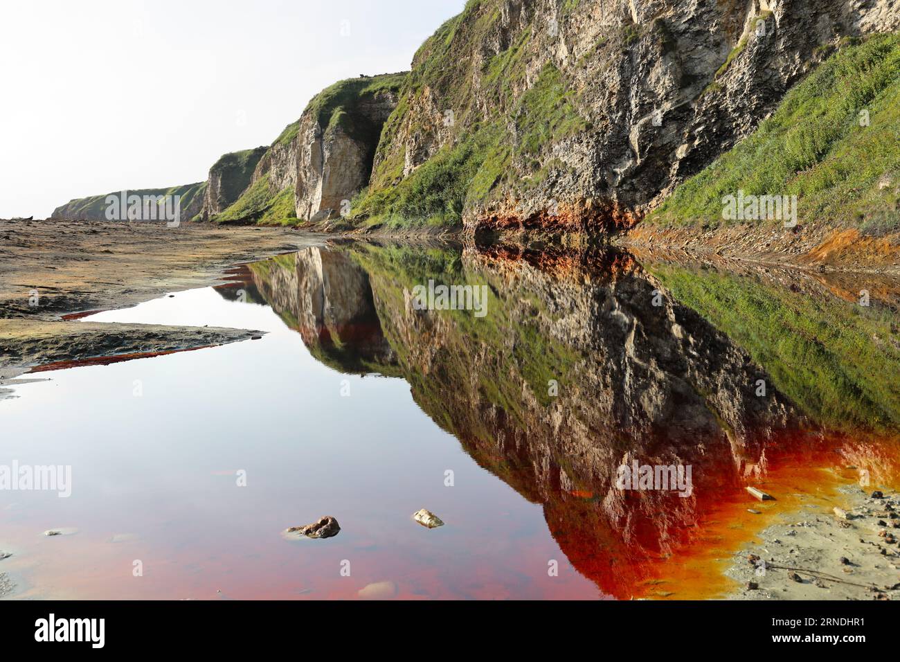 Piscine rosse di sangue con coste di zolfo gialle sulla Blast Beach, Durham Heritage Coast, Seaham, County Durham, UK Foto Stock