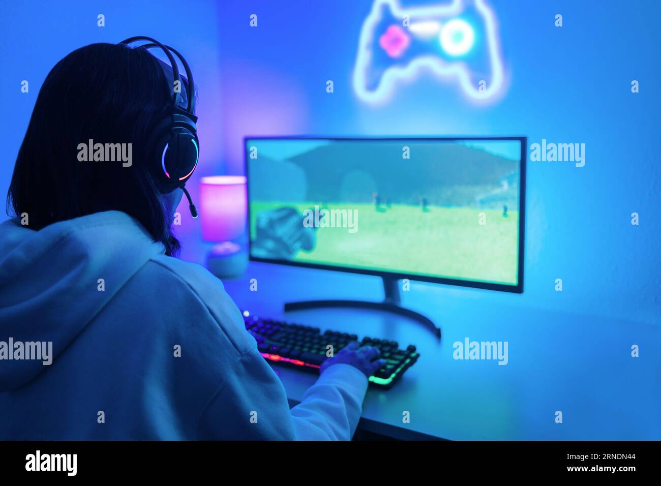 Giovane gamer che gioca ai videogame online per pc mentre è in streaming durante il concorso Esport - donna che si diverte a partecipare al concorso di gioco Foto Stock