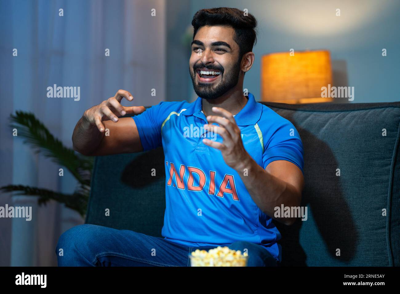 Emotional Young man che celebra la vittoria della squadra di cricket indiana mentre guardi in tv a casa - concetto di felicità vincente, momenti emotivi e. Foto Stock