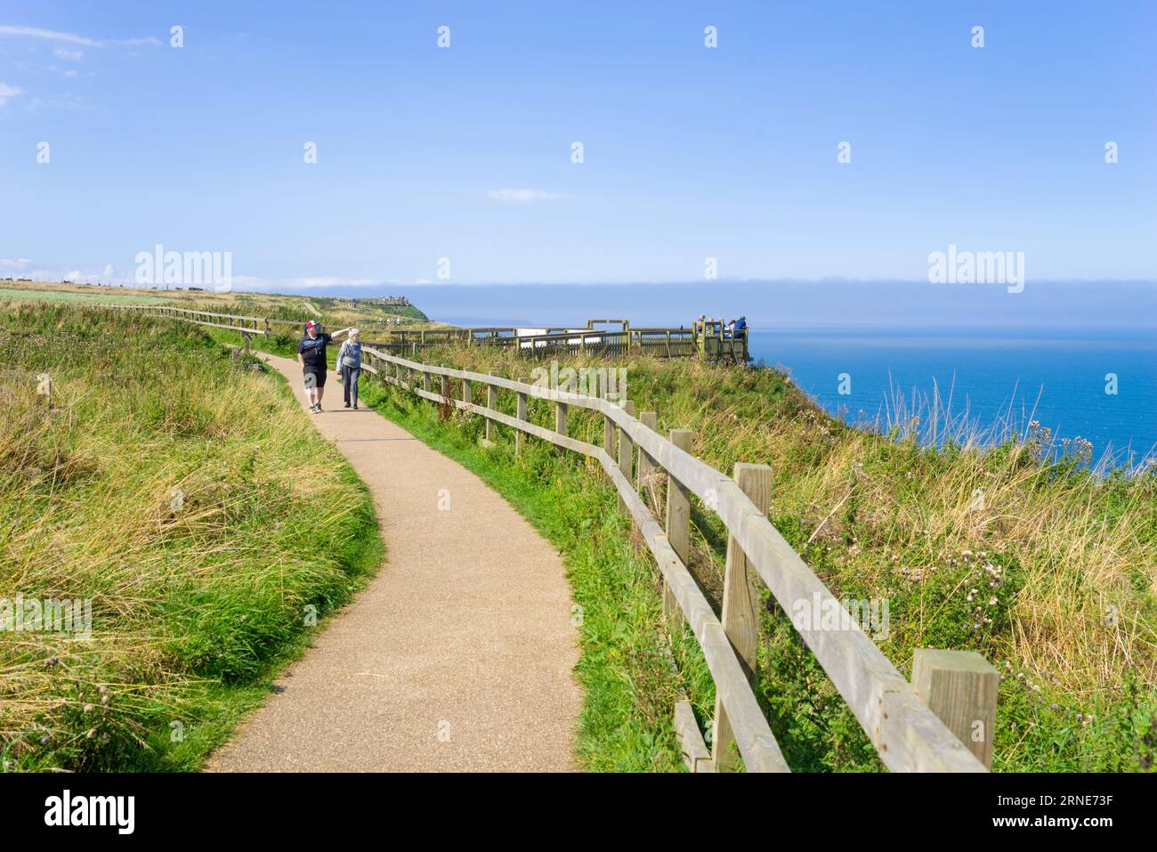 Scogliere di Bempton due persone camminano lungo il sentiero in cima alla scogliera presso la riserva RSPB Bempton East Riding della costa dello Yorkshire Inghilterra regno unito gb Europa Foto Stock